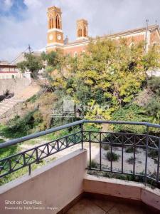 a building with a clock tower on top of a hill at Sweet studio in Pyrgos city near Olympia in Pyrgos