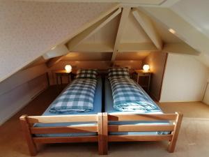 two beds in a room with an attic at Holiday home bos en heide in Otterlo