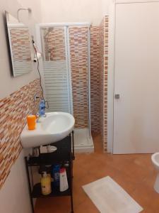 bagno con lavandino bianco e specchio di Casa Normanna a Salerno