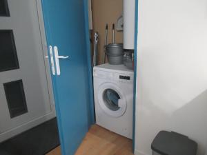 een badkamer met een wasmachine en een blauwe deur bij Gîte la Chaumette appartement Turquoise in Villeneuve-de-Berg