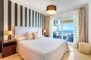 a bedroom with a bed and a view of the ocean at Ceres Luxury Apartment in Rincón de la Victoria