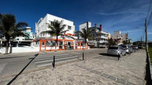 un estacionamiento con autos estacionados frente a un edificio en Pousada Águas do Mariscal en Bombinhas