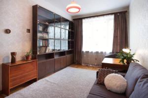 a living room with a couch and a book shelf at City Center Huge 3-Bedroom Apartment in Tallinn
