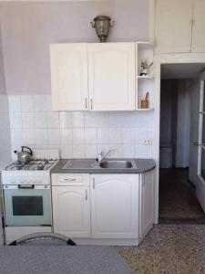 a white kitchen with a sink and a stove at City Center Huge 3-Bedroom Apartment in Tallinn