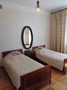 una camera con due letti e uno specchio a muro di City Center Huge 3-Bedroom Apartment a Tallinn