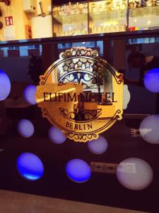 a reflection of a sign in a window with blue lights at Elifim in Berlin