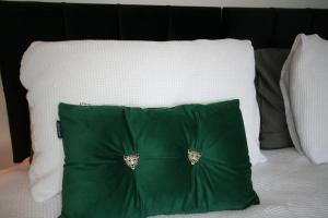 a green pillow sitting on top of a bed at The Lodgings 3 Bed Cottage suitable for families breaks, working away Lincoln in Laneham