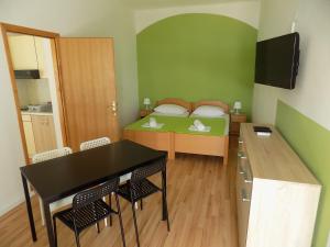 Habitación pequeña con cama, mesa y sillas en Apartments Galeb Pag - Beach, en Pag