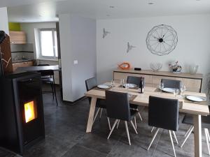 a dining room with a table and a fireplace at Le gîte des Kritter in Stosswihr