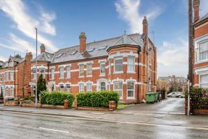 a large red brick building on a city street at Guest Homes - Droitwich Road Apartment in Worcester