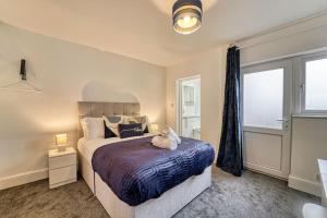 a bedroom with a bed with a teddy bear on it at Guest Homes - Droitwich Road Apartment in Worcester