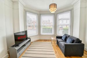 a living room with a couch and a tv at Guest Homes - Droitwich Road Apartment in Worcester