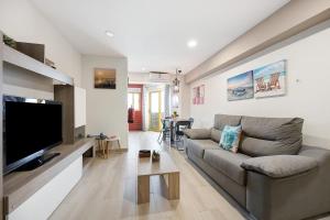 a living room with a couch and a flat screen tv at Karol Vaz in Portimão