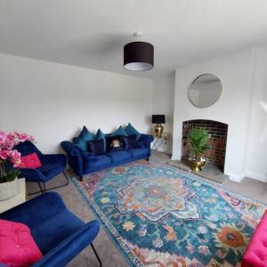 a living room with a blue couch and a rug at The Lodgings 3 Bed Cottage suitable for families breaks, working away Lincoln in Laneham