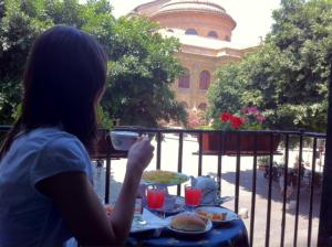 Una donna seduta a un tavolo con un piatto di cibo di Massimo Plaza Hotel a Palermo