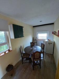- une cuisine avec une table et des chaises dans la chambre dans l'établissement OLOR Apartman 2 - Banoštor, à Banoštor