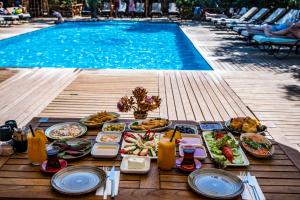 una mesa con comida junto a la piscina en Dolce Vita Luxury Bungalows en Bodrum