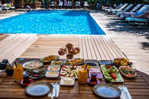 a table with food next to a swimming pool at Dolce Vita Luxury Bungalows in Bodrum City