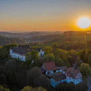 une vue aérienne sur un domaine avec le coucher du soleil en arrière-plan dans l'établissement Hotel & Tagungszentrum Schloss Hohenfels, à Hohenfels