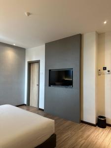 a bedroom with a bed and a flat screen tv at The Gallivant Hotel in George Town
