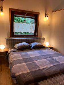 een slaapkamer met een groot bed en een raam bij Gîte L'Orée 