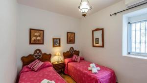 a bedroom with two twin beds and a window at Cortijo los Valles Alozaina by Ruralidays in Alozaina