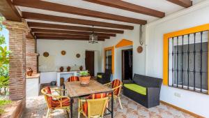 d'une terrasse avec une table et des chaises en bois. dans l'établissement Cortijo los Valles Alozaina by Ruralidays, à Alozaina