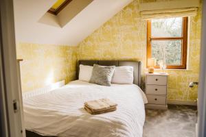 a bedroom with a white bed with yellow wallpaper at Valley Lodge Enniskillen in Glenross