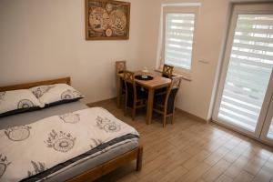 a bedroom with a bed and a table with chairs at Dębowe Zacisze in Dębina