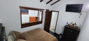 a room with a couch and a window and a television at HOSPEDAJE DE GUATAVITA in Guatavita