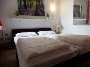um quarto com 2 camas e lençóis brancos em Ferienpark Sierksdorf App 425 - Strandlage em Sierksdorf