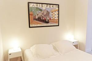 a bedroom with a poster of a train on the wall at La Rotonde - Appartement 1 chambre aux Chartrons in Bordeaux
