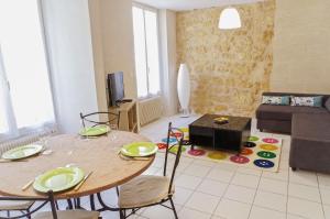 - un salon avec une table, des chaises et une télévision dans l'établissement La Rotonde - Appartement 1 chambre aux Chartrons, à Bordeaux