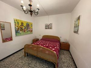 - une chambre avec un lit et un lustre dans l'établissement Appartamento vicino al mare, à Moneglia