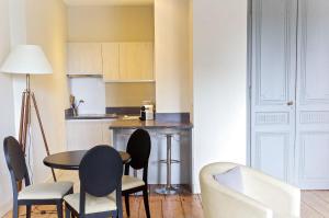 - une cuisine avec une table et des chaises dans la chambre dans l'établissement Saint Rémi - Appartement 1 chambre avec ascenseur, à Bordeaux