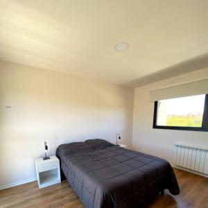Un dormitorio con una cama grande y una ventana en Casita Sur Trevelin en Trevelin