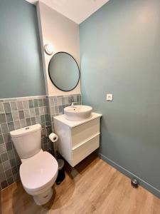 a bathroom with a white toilet and a sink at Isis - SILS in Caen