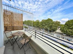 a balcony with a table and chairs on a roof at Isis - SILS in Caen