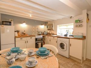 a kitchen with a table with blue and white dishes on it at Cosy Cottage in Bawdeswell
