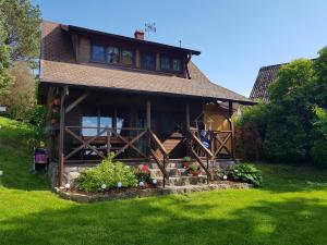 a large house with a porch and a yard at Domek Letniskowy Monika in Jeziorowskie