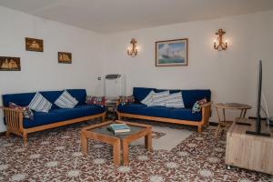 a living room with two blue couches and a table at Be Your Home - Appartamento 4 camere sul Mare scesa al mare privata in Santa Marinella