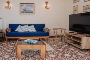 a living room with a blue couch and a tv at Be Your Home - Appartamento 4 camere sul Mare scesa al mare privata in Santa Marinella