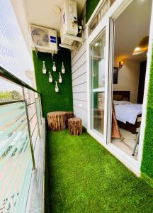 a small balcony with green grass and a bedroom at 3BHK Airport Vista Apartment - Entire Apartment in Jaipur