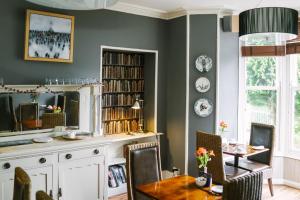 a dining room with green walls and a table and chairs at Rum Doodle, Windermere B&B in Windermere