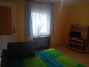 a bedroom with a green bed and a window at D38 Pestelizabeth Apartman in Budapest