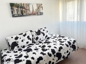 1 cama con sábanas de vaca blancas y negras en Apartamento Pandora, en Yecla