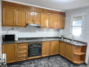 una cocina con armarios de madera y fregadero en Apartamento Pandora, en Yecla