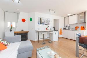 a living room with a couch and a kitchen at Apartamento Ático Las letras in Madrid