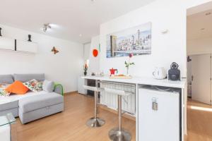 cocina y sala de estar con sofá y mesa en Apartamento Ático Las letras, en Madrid
