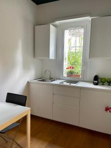 a white kitchen with a sink and a window at Garden house in Rome